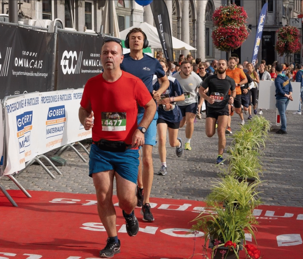 Exhausted runner pushing through fatigue just meters before crossing the finish line of first official 5K race.