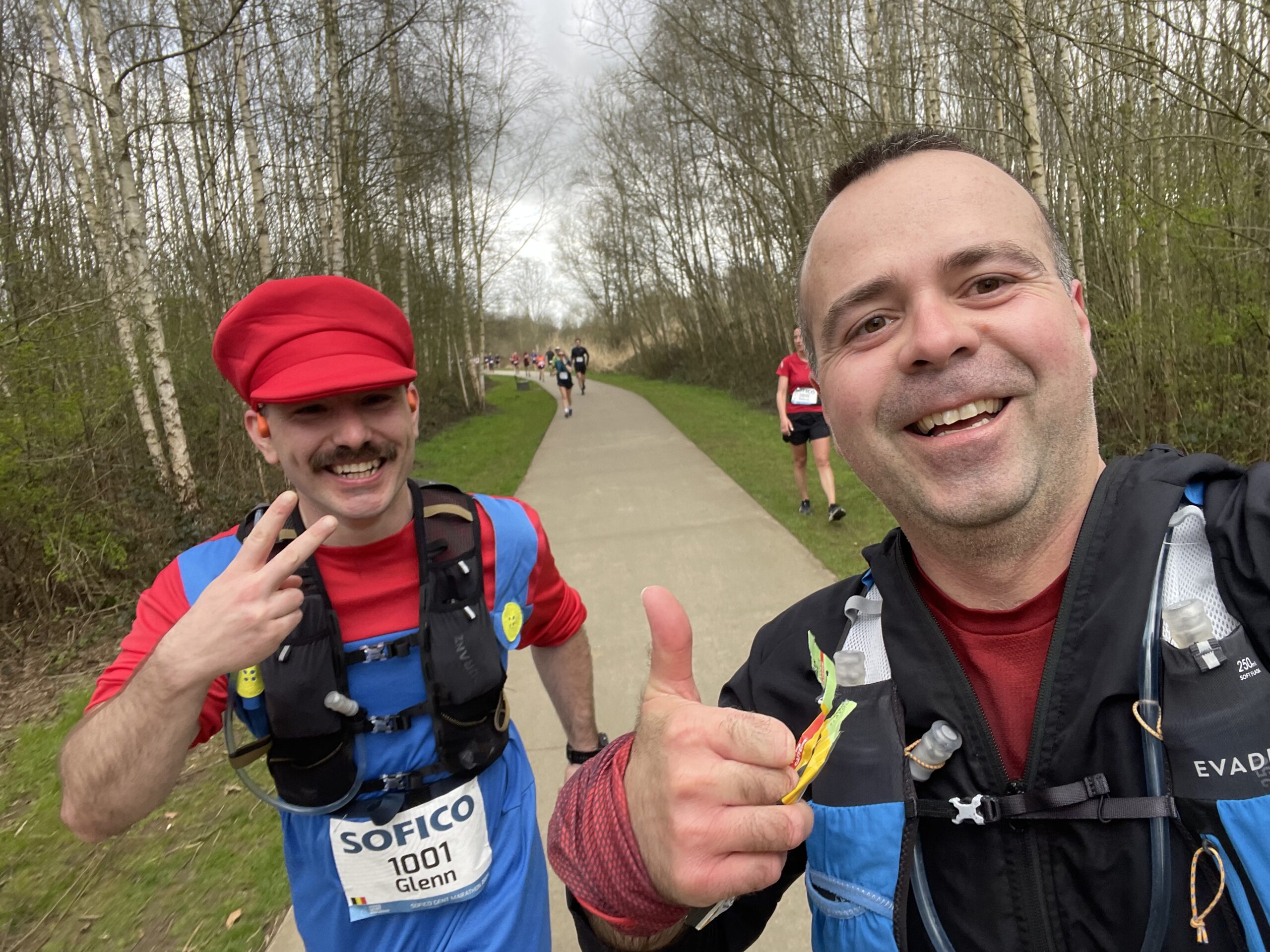 Runner mid-stride during their first marathon, with another runner dressed as Mario running alongside.