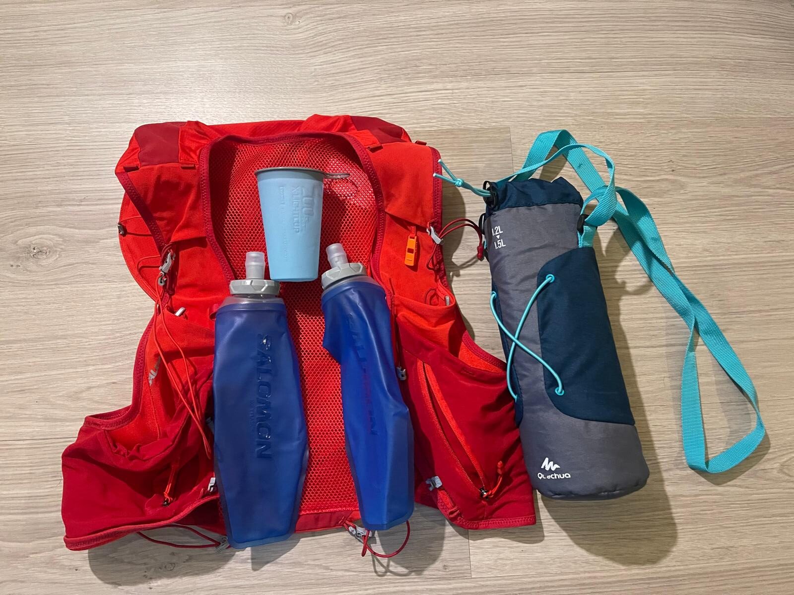 Salomon ADV Skin 12 running vest with 500 ml soft flasks, foldable cup, and Quechua isothermal cover.
