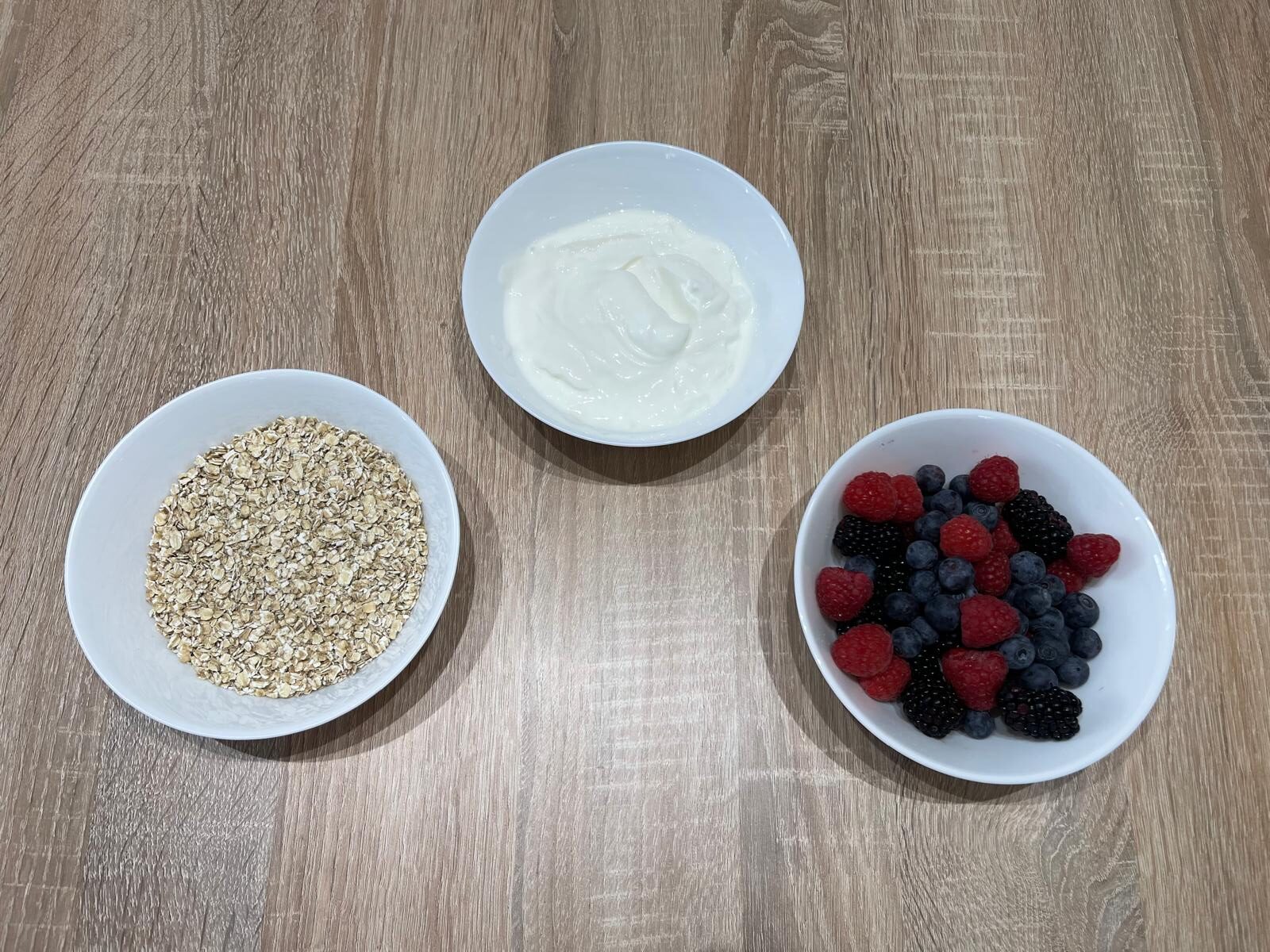 Greek yogurt with oats and forest berries including blueberries, blackberries, and raspberries as a healthy recovery snack for runners.