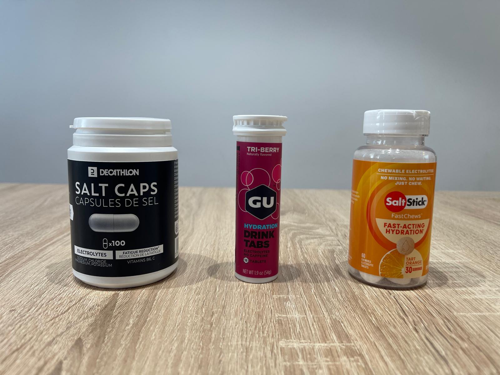 Electrolyte supplements for runners including Decathlon salt tablets, GU hydration drink tabs, and SaltStick FastChews for fast hydration during long runs.